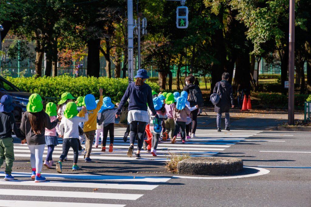 横断歩道を渡る園児と先生。