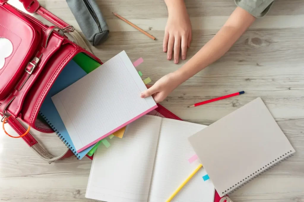 ランドセルからノートを取り出す子どもの手元と学用品